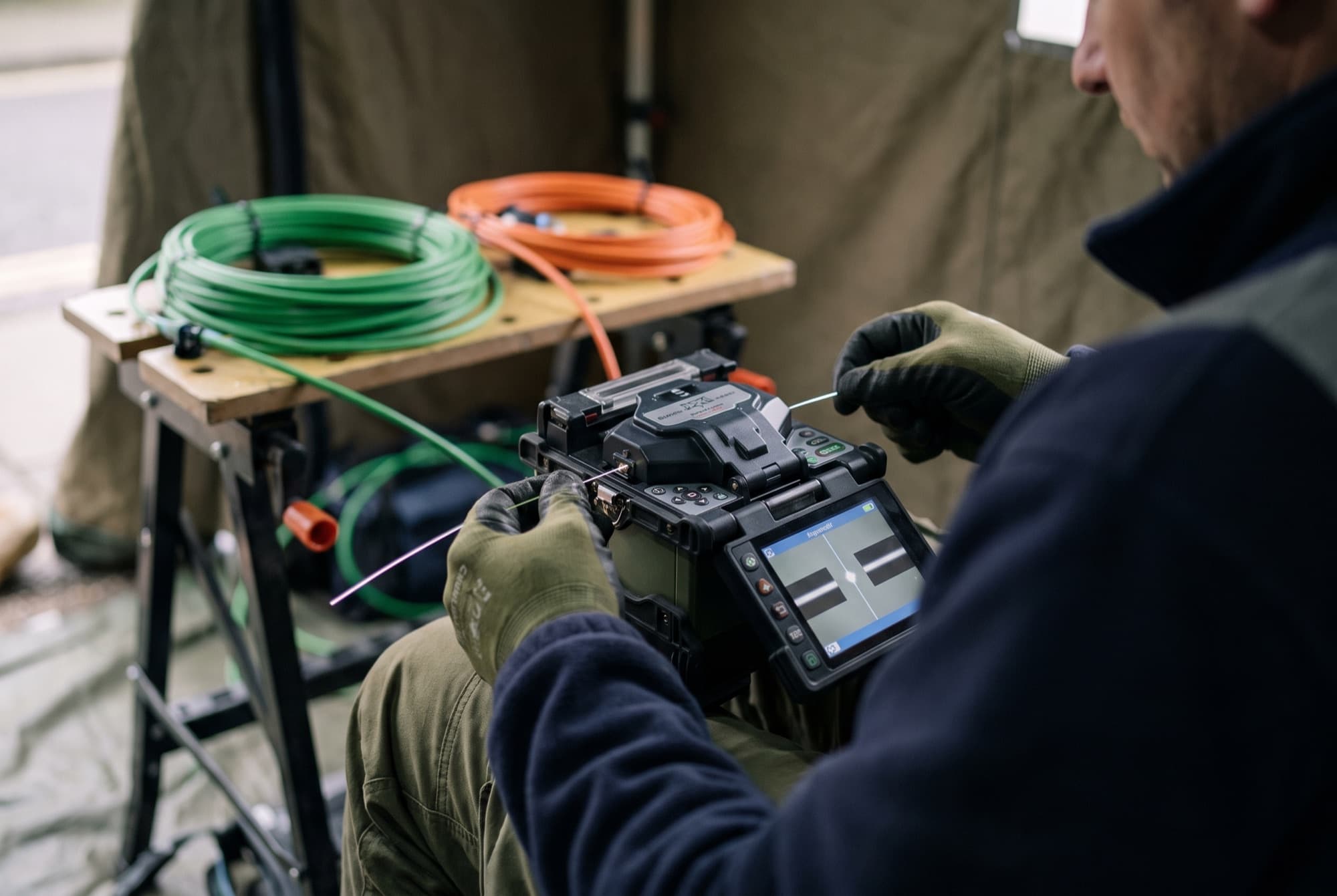 A technician fusion-splicing fibre in the field